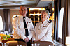 Uniformene i restauranten om bord på MS Vesterålen har hentet inspirasjon fra Hurtigrutens historie. Til venstre Harald Aamaas, som har lang fartstid hos Hurtigruten.